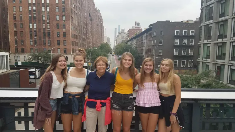 Visitors on the High Line with Chelsea buildings behind them on a New York architecture tour of the elevated park