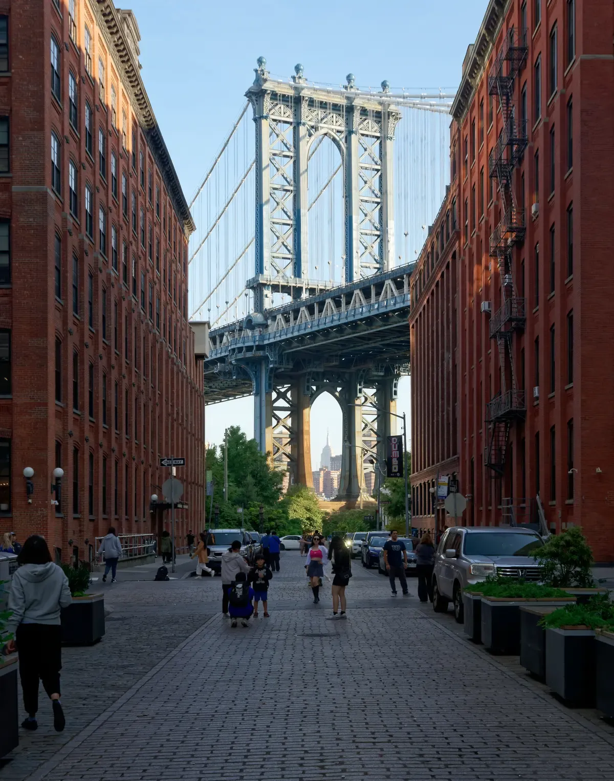The Manhattan Bridge framed by brick warehouses on Washington Street in DUMBO with the Empire State Building beyond, on a New York architecture tour