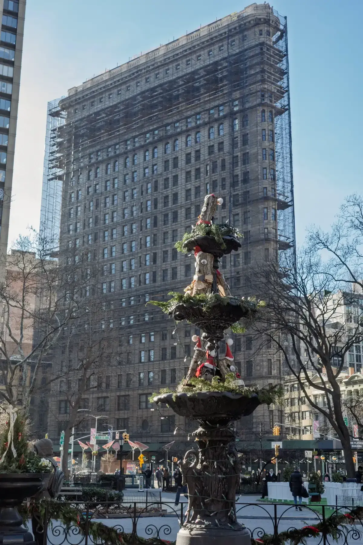 The Flatiron Building rising behind the Madison Square Fountain in Madison Square Park, on a New York architecture tour