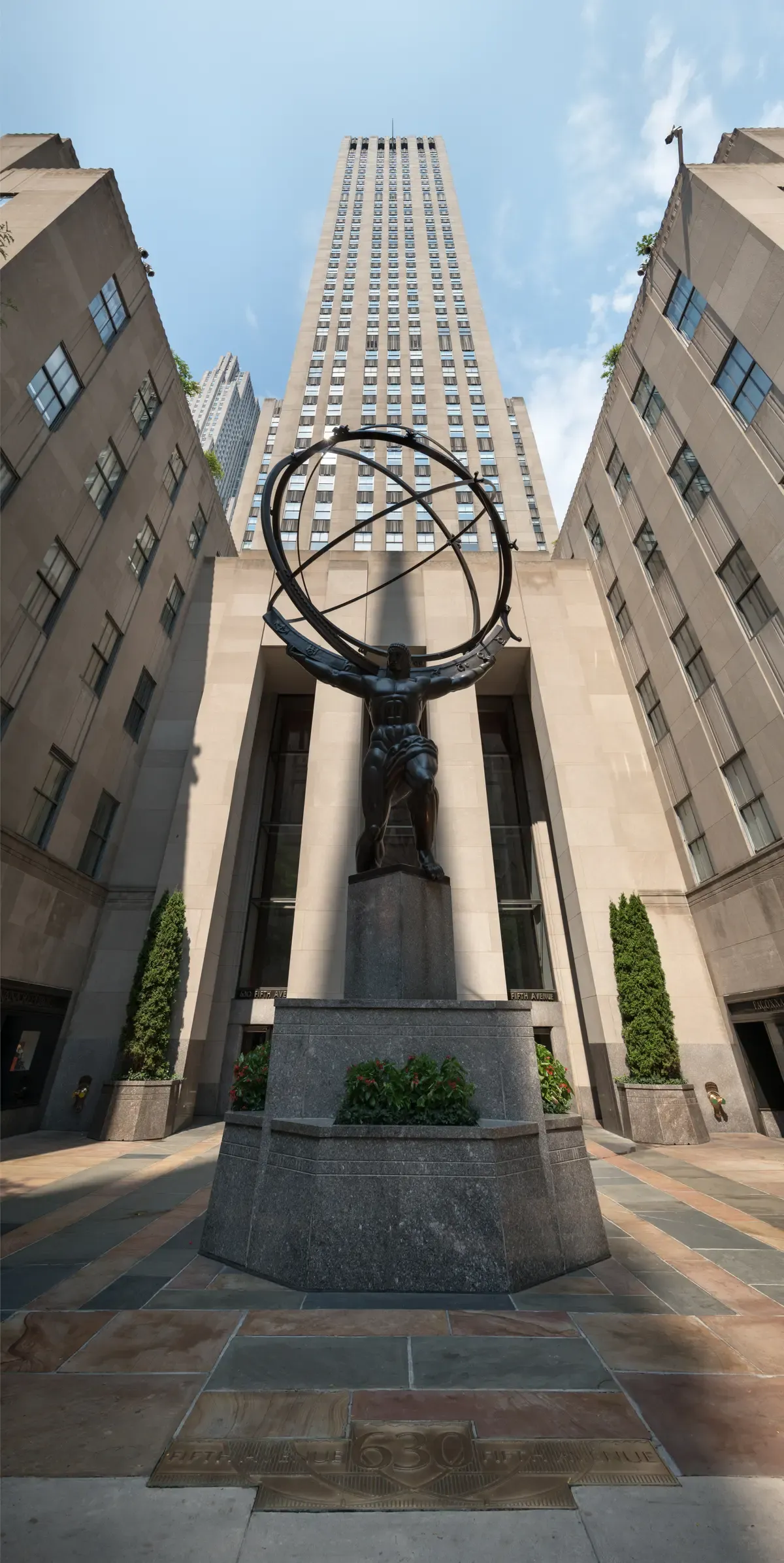 The bronze Atlas statue at Rockefeller Center with 30 Rockefeller Plaza rising behind it, on a New York architecture tour