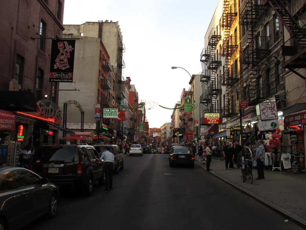 Mulberry Street in Little Italy lined with restaurants and fire escapes, on a New York architecture tour