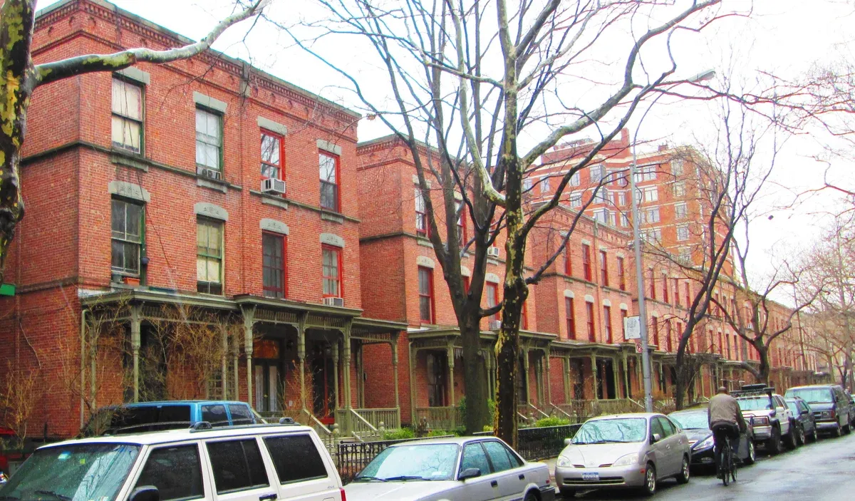 Red-brick Astor Row houses with wooden porches on West 130th Street in Harlem, on a New York architecture tour
